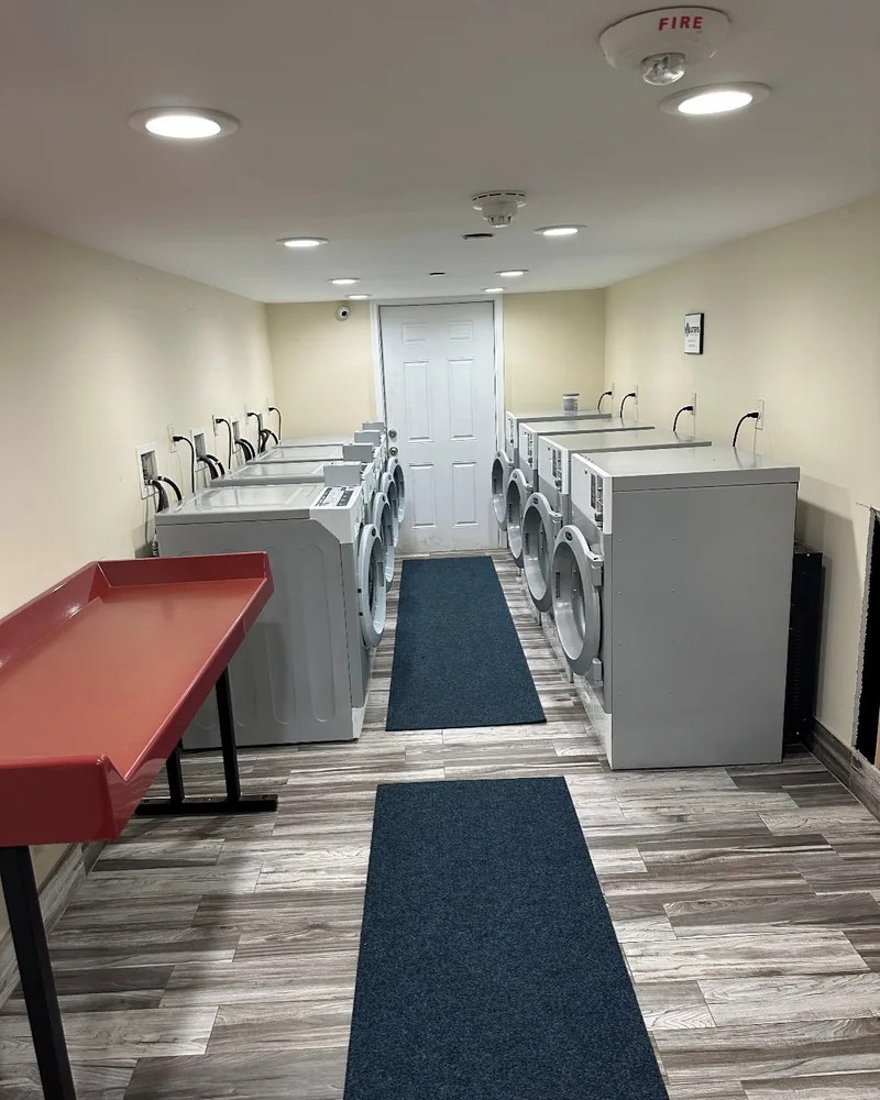 Resident laundry room in an apartment building, with washers and dryers along both walls and a folding table